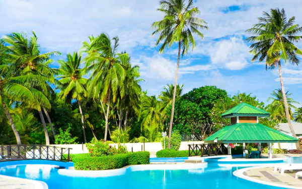 4K Ultra HD wallpaper of a tropical resort featuring a clear blue pool, palm trees, and a green-roofed gazebo under a bright sky.