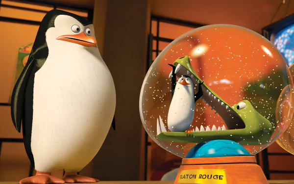 HD PC desktop wallpaper from the movie Penguins of Madagascar: a penguin stands beside a glass dome holding another penguin and a toothy crocodile.