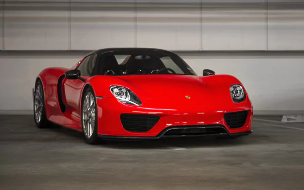 A striking red Porsche 918 Spyder showcased in a sleek garage setting, capturing the essence of luxury and performance as an HD desktop wallpaper.