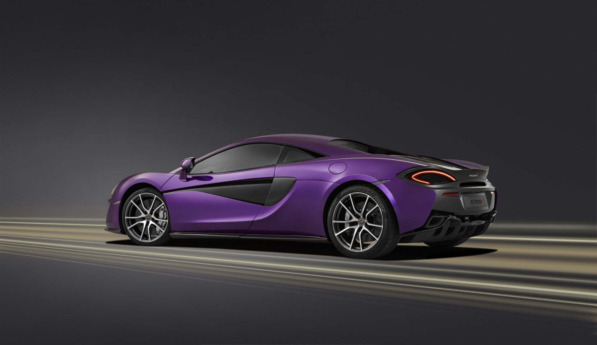 A sleek purple McLaren 570S supercar captured in a 4K Ultra HD wallpaper, showcasing its aerodynamic design and sporty elegance against a dark background.