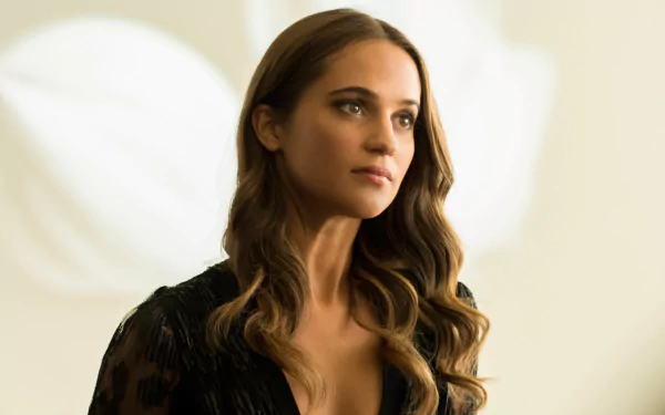 Alicia Vikander, a Swedish actress with brown eyes and brunette hair, gazes thoughtfully, showcasing elegance and poise in this HD wallpaper backdrop.