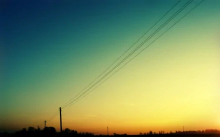 HD desktop wallpaper showing man-made power lines silhouetted against a gradient sky at sunset.