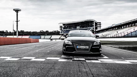 Front view of a black Audi TT sports car on a racetrack starting line, high-contrast 2K Quad HD PC desktop wallpaper/background.