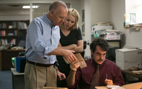 Scene from the 2015 movie Spotlight featuring Brian d'Arcy James, Michael Keaton, and Rachel McAdams examining documents in an office, rendered as a 4K Ultra HD desktop wallpaper.