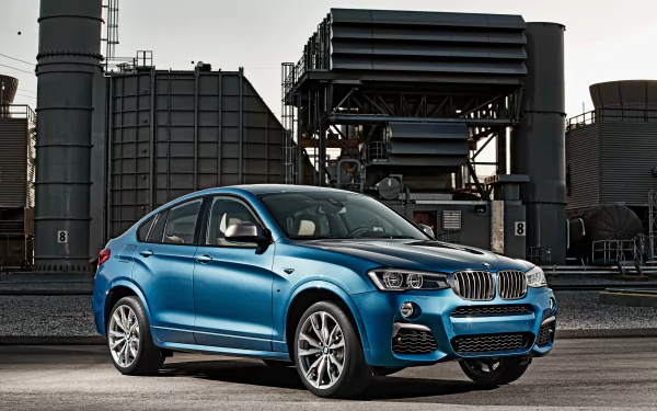 Blue BMW X4 SUV parked before an industrial plant — 4K Ultra HD PC desktop wallpaper/background.