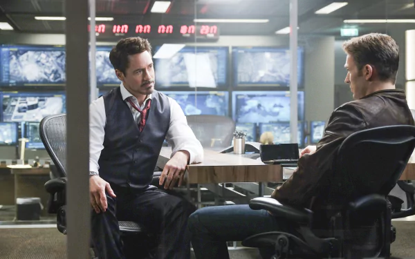 Tony Stark and Steve Rogers engage in a tense discussion in a high-tech setting from *Captain America: Civil War*, featuring Robert Downey Jr. and Chris Evans. HD wallpaper.