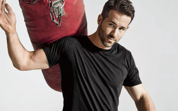 HD desktop wallpaper featuring Canadian actor Ryan Reynolds with a beard, dressed in a black t-shirt, posing confidently against a neutral background.