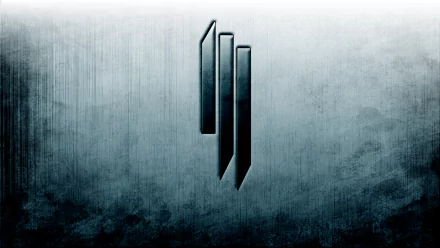 A sleek HD desktop wallpaper featuring the iconic Skrillex logo, set against a textured gray background, embodying the energy of electronic music.