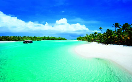 Tropical beach with white sand and turquoise lagoon under a vivid blue sky, framed by lush palm trees and calm ocean waters, captured in HD for a desktop wallpaper.