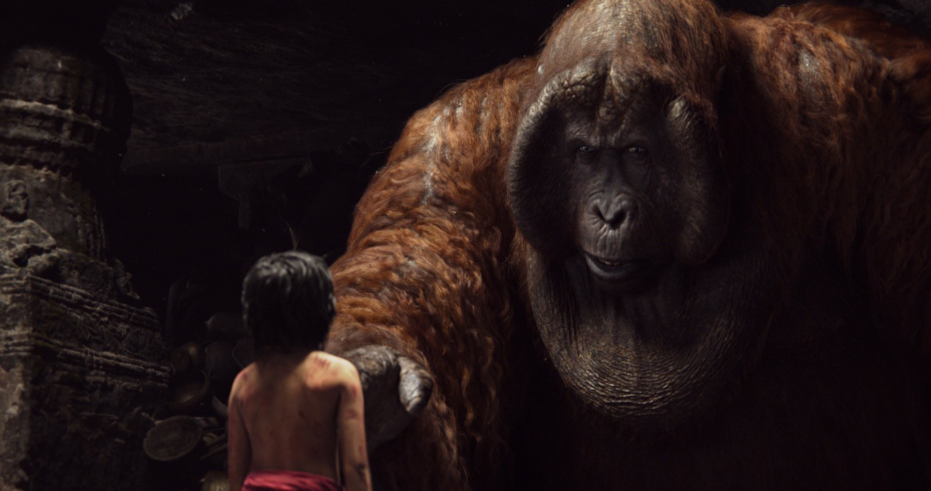 A young boy faces a large orangutan in a scene from the movie The Jungle Book (2016), set in a richly detailed jungle environment. HD wallpaper background captures this moment beautifully.