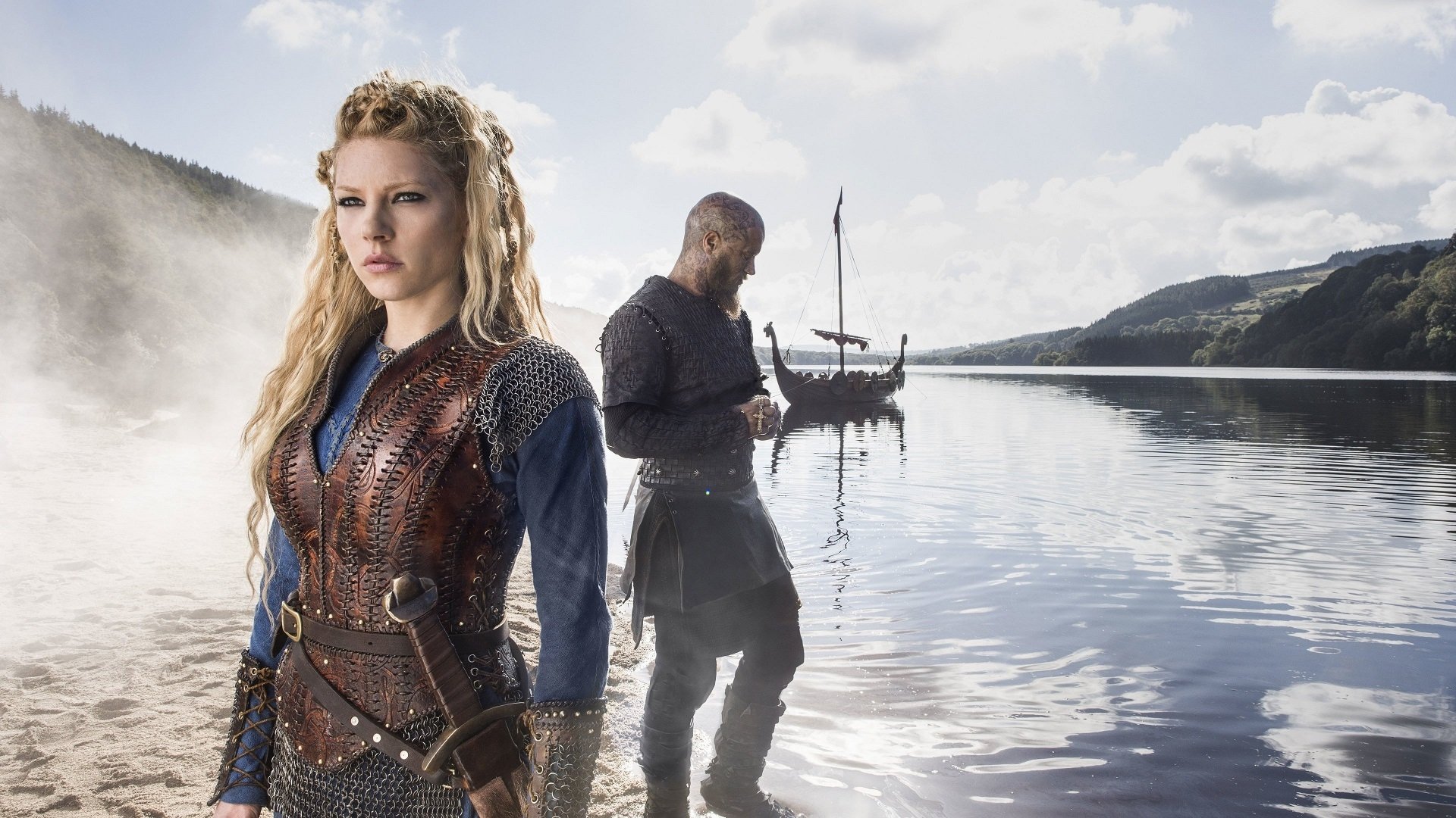 HD PC wallpaper of Lagertha from the TV show Vikings (2013): a blonde shieldmaiden in leather armor stands by a misty fjord while a warrior and longship pause on the water.