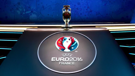 A vibrant HD wallpaper featuring the UEFA Euro 2016 logo and trophy on a sleek table, capturing the spirit of the tournament in a dynamic sports-themed backdrop.