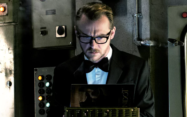 A scene from *Mission: Impossible - Rogue Nation*, featuring a man in a tuxedo, focused on a device amidst a backdrop of control panels, showcasing high-stakes espionage.