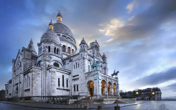The Basilica of Sacré-Cœur in Paris, France, showcases its iconic dome and intricate religious architecture against a dramatic sky in this 4K Ultra HD desktop wallpaper.