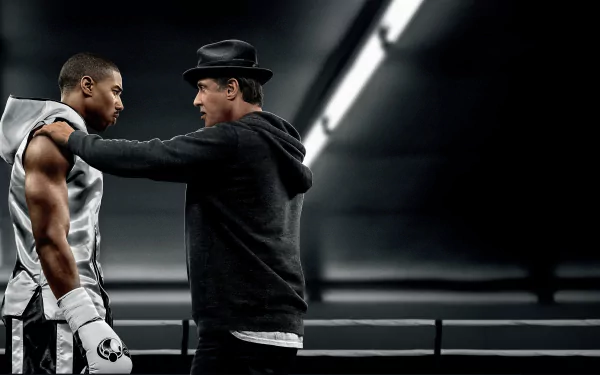 Adonis Creed and Rocky Balboa, played by Michael B. Jordan and Sylvester Stallone, share a moment in a 4K Ultra HD wallpaper from the movie Creed.