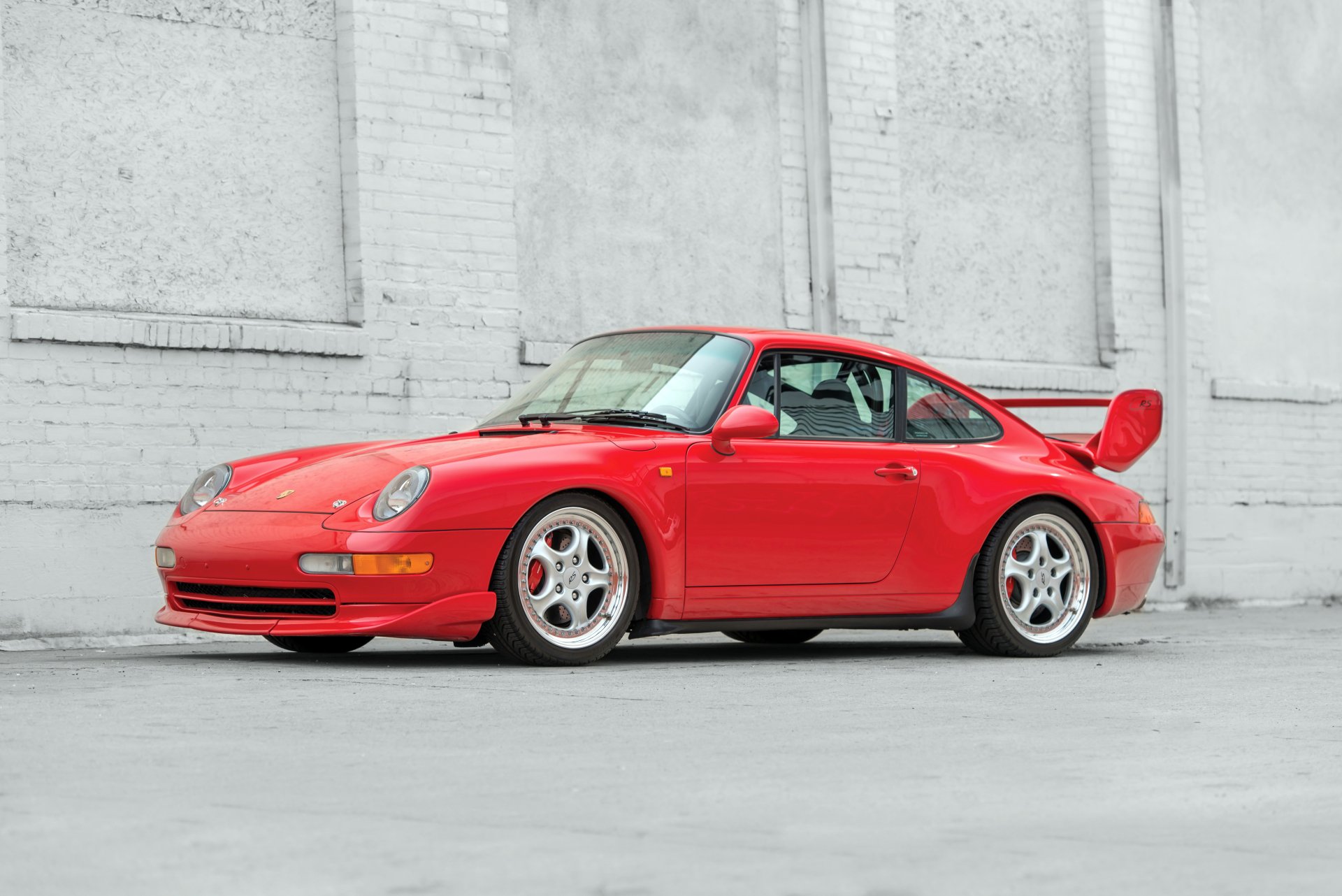 Red Porsche 911 Carrera vehicle parked against a pale concrete wall — 4K Ultra HD PC desktop wallpaper and background
