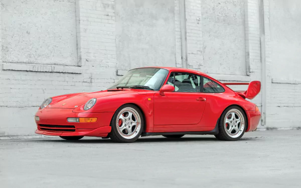 Red Porsche 911 Carrera vehicle parked against a pale concrete wall — 4K Ultra HD PC desktop wallpaper and background