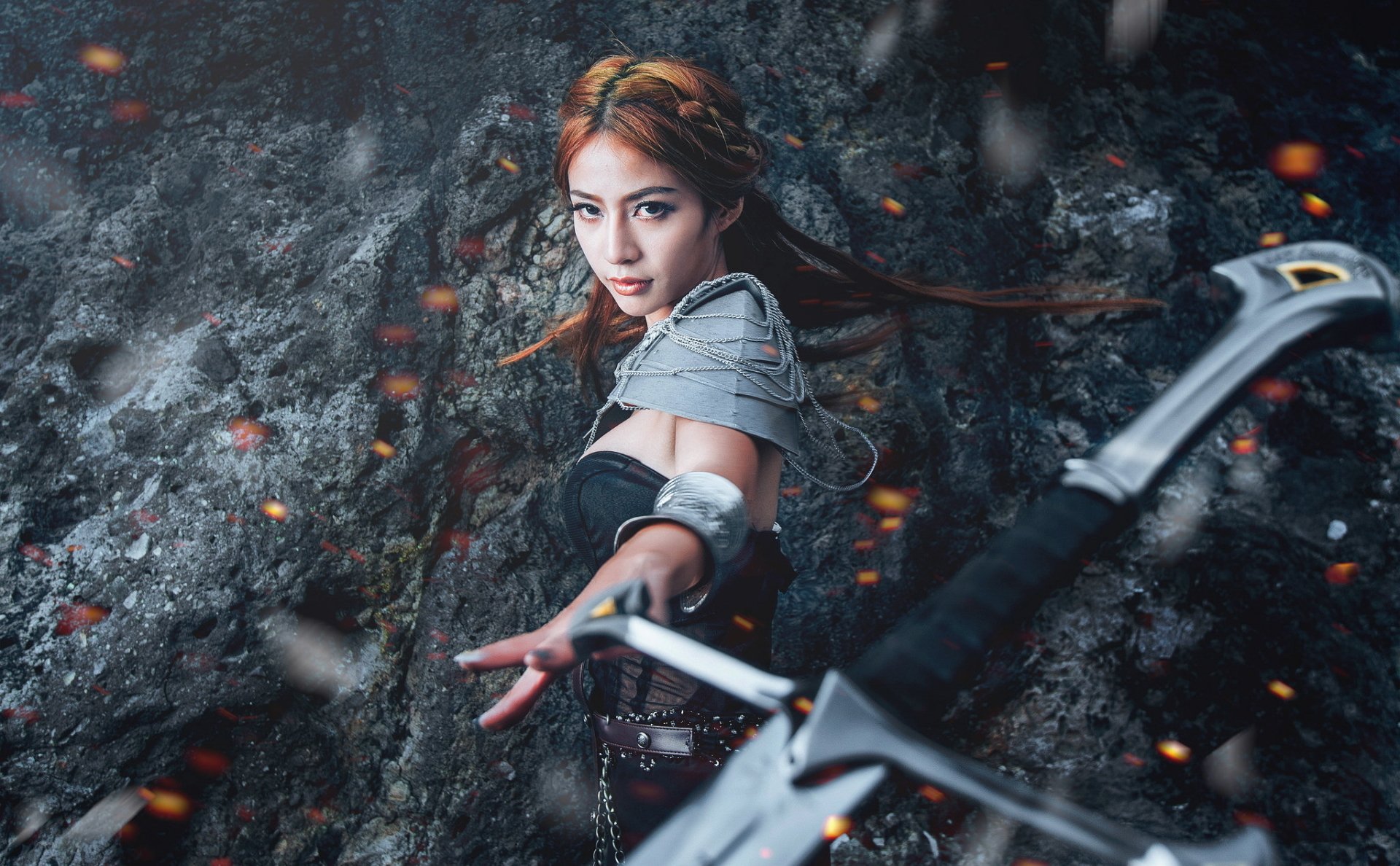 A woman in stunning oriental cosplay wields a sword, poised dramatically against a rocky backdrop, creating a captivating HD desktop wallpaper.