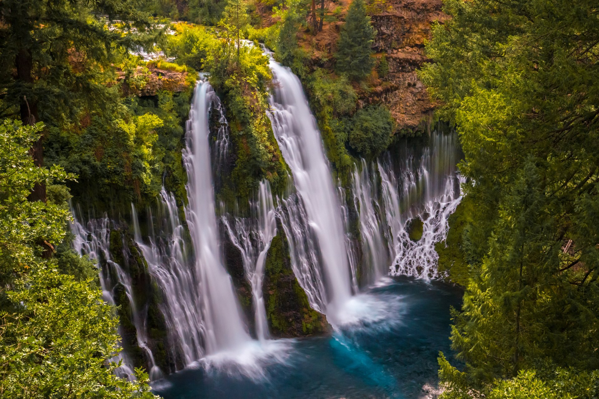 Burney Falls, a California waterfall tumbling over a mossy cliff into a turquoise pool, framed by lush nature — 5K Ultra HD PC desktop wallpaper background.