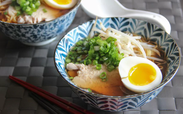 Close-up of a bowl of ramen with green onions, soft-boiled egg, and broth, styled in a 4K Ultra HD PC desktop wallpaper quality.