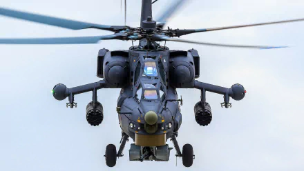 Close-up HD image of a military Mil Mi-28 helicopter in flight, highlighting its detailed design against a clear sky background.