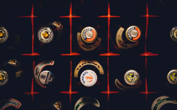 4K Ultra HD wallpaper featuring an artistic overhead view of various beer bottle caps arranged on a dark grid background, highlighting food and beer elements.