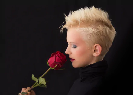Blonde woman with bold makeup and red lipstick holding a red rose close to her face against a black background in 4K Ultra HD.