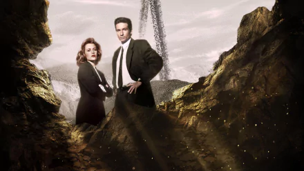 HD desktop wallpaper featuring Gillian Anderson as Dana Scully and David Duchovny as Fox Mulder from the TV show The X-Files, standing in a rocky, dramatic landscape.