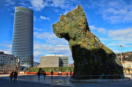 4K Ultra HD PC desktop wallpaper: Bilbao, Spain — Guggenheim Museum's man-made floral Puppy statue beside the Iberdrola Tower under a bright blue sky.