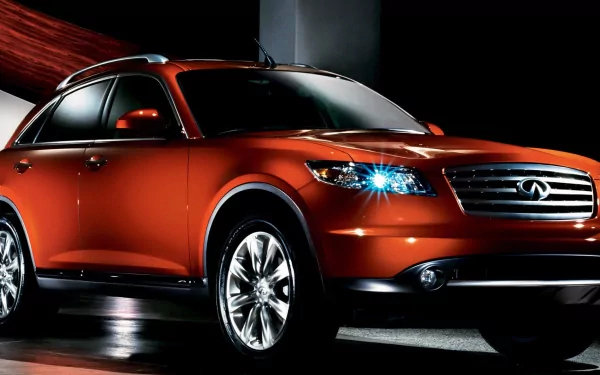 HD PC desktop wallpaper featuring a sleek, orange Infiniti QX70 vehicle with illuminated headlights against a dark background.