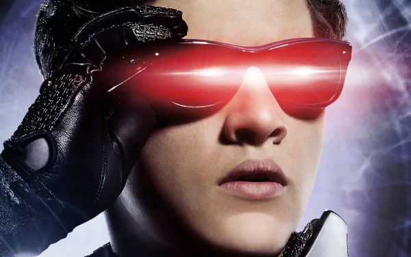 A close-up of Scott Summers, portrayed by Tye Sheridan, showcasing Cyclops from *X-Men: Apocalypse*. He wears iconic sunglasses as red beams emanate, highlighting his mutant powers.