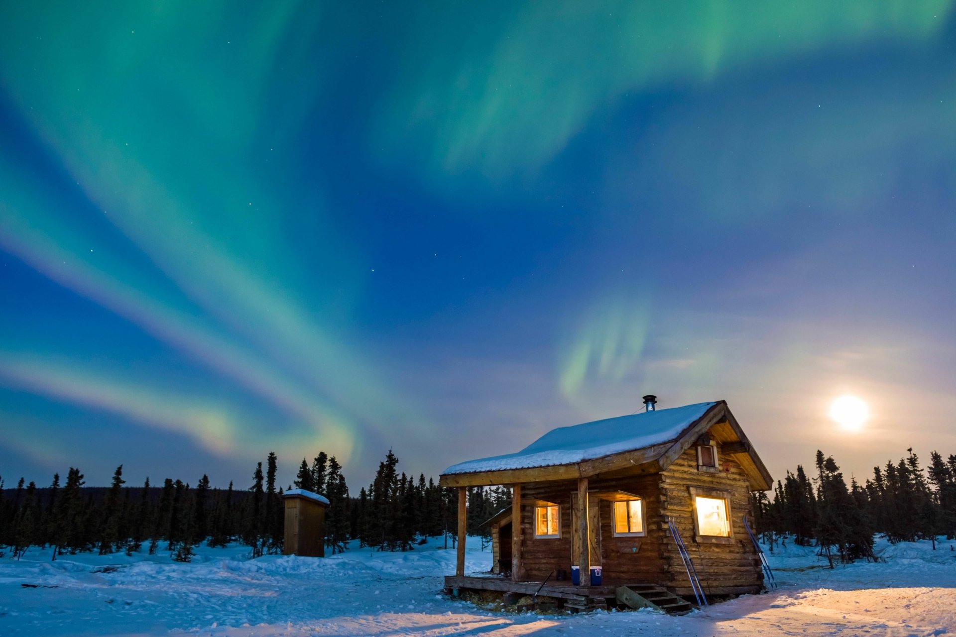 A cozy cabin surrounded by snow in winter nature, illuminated under a vibrant aurora borealis sky, captured in stunning 4K Ultra HD.