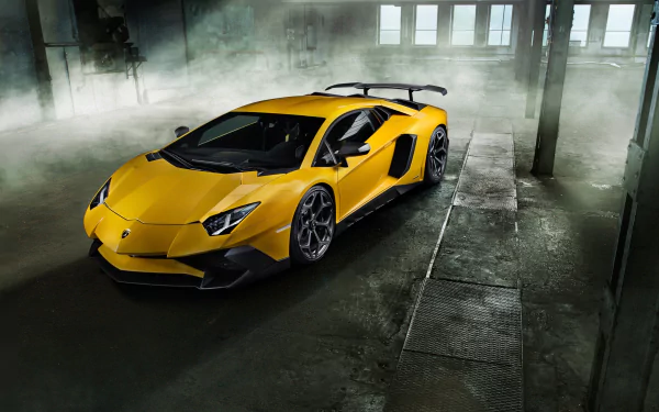 A high-definition desktop wallpaper featuring a striking yellow Lamborghini Aventador SV parked in an industrial setting with ambient lighting and a misty atmosphere.