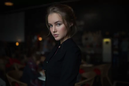 HD desktop wallpaper featuring a brunette woman model in a dark, softly lit setting with a blurred background.