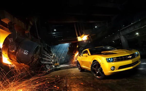 Yellow Chevrolet Camaro SS muscle car showcased in a dark industrial setting with sparks flying, captured in high definition for a PC desktop wallpaper and background.