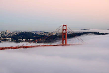 HD desktop wallpaper featuring the man-made Golden Gate Bridge in San Francisco emerging through a blanket of fog at sunrise.
