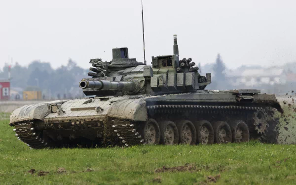 A military T-72 tank maneuvers through a grassy field, showcasing its robust design and operational capabilities, set against a soft-focus background. HD desktop wallpaper.