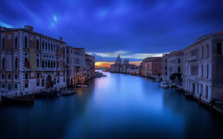 Dusk view of Venice’s Grand Canal with historic architecture reflecting on calm waters under a deep blue sky, captured in an HD desktop wallpaper.