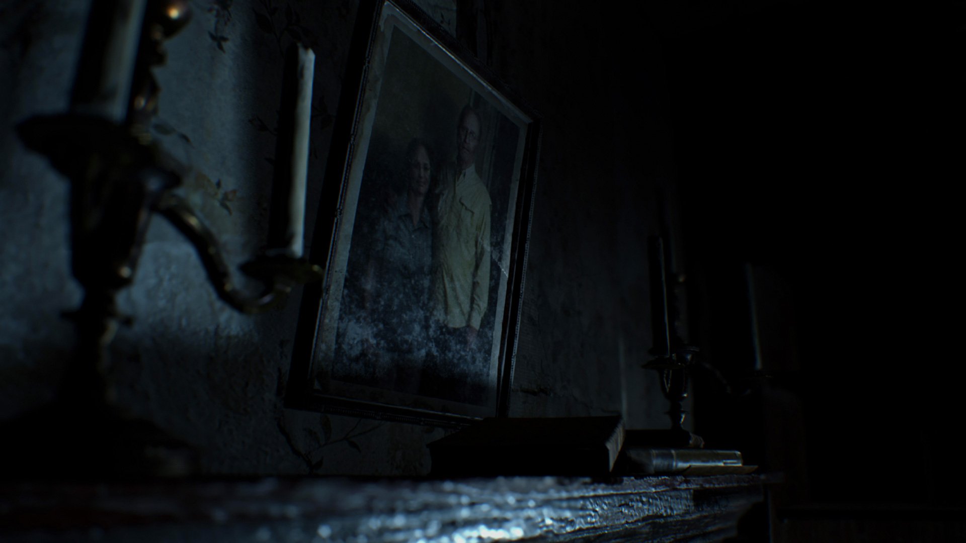 Dark, moody HD PC desktop wallpaper from the video game Resident Evil 7: Biohazard, showing a shadowed portrait on a grimy mantel in a decaying, dimly lit room.