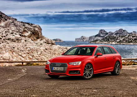 A striking red Audi A4 parked near a scenic coastline, surrounded by rocky terrain and a calm sea, making for a stunning HD desktop wallpaper.