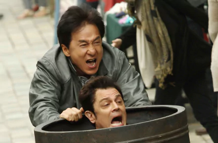 Jackie Chan and Renny Harlin in a comedic scene from the movie *Skiptrace* (2016), showcasing their dynamic as they navigate a humorous chase. HD desktop wallpaper.