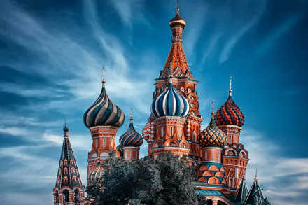 Vivid HD desktop wallpaper of Saint Basil's Cathedral in Moscow, Russia — colorful onion domes and ornate religious architecture under a dramatic blue sky.