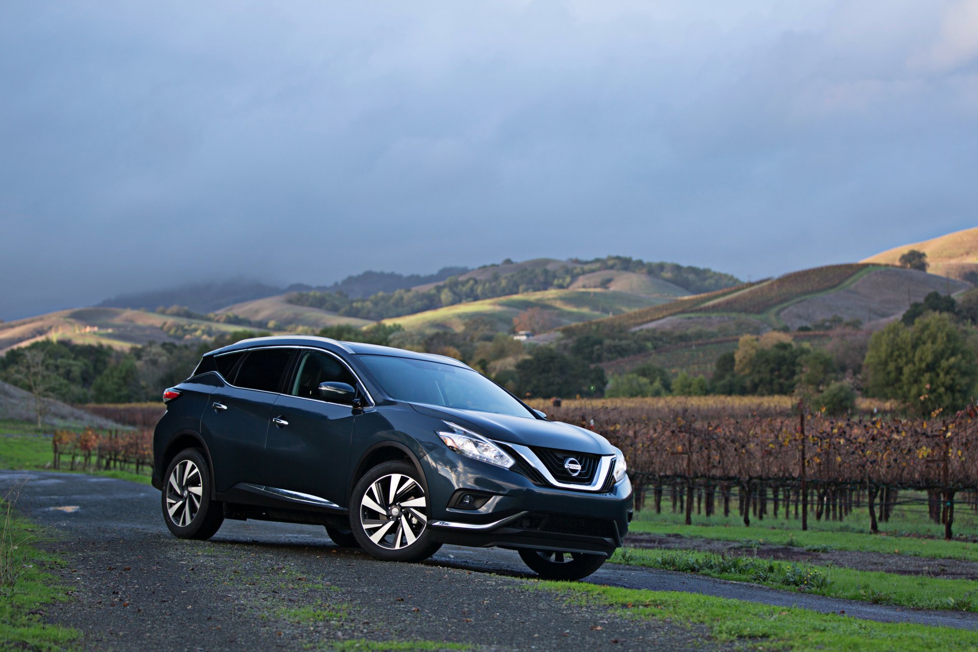 Black Nissan Murano SUV car parked on a country road with rolling hills and vineyards — 4K Ultra HD PC desktop wallpaper/background featuring a sleek Nissan vehicle.