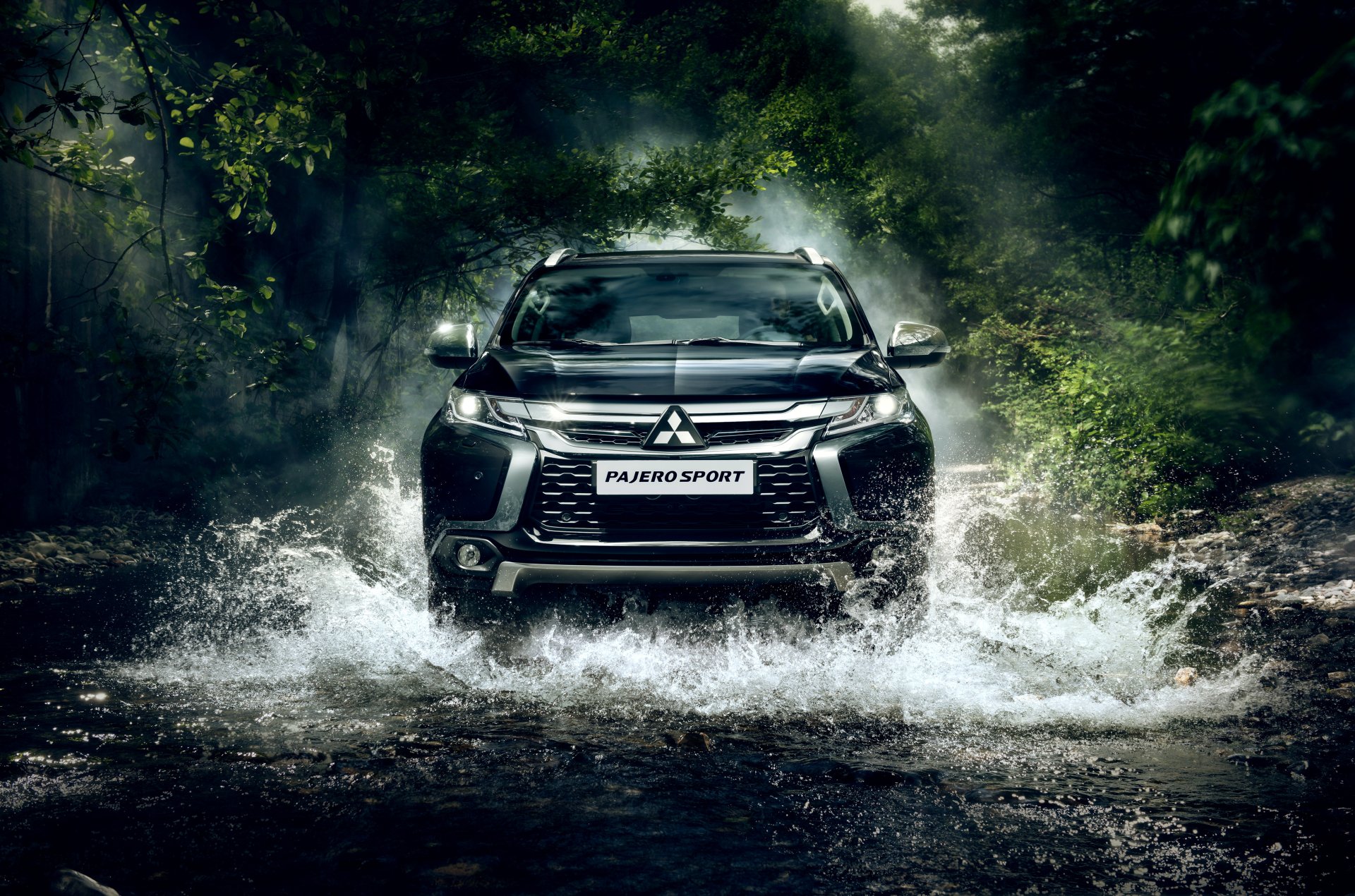 Black Mitsubishi Pajero SUV splashes through a forest stream in this 4K Ultra HD desktop wallpaper, showcasing rugged off-road capability and sleek design.