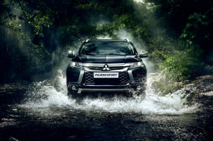 Black Mitsubishi Pajero SUV splashes through a forest stream in this 4K Ultra HD desktop wallpaper, showcasing rugged off-road capability and sleek design.