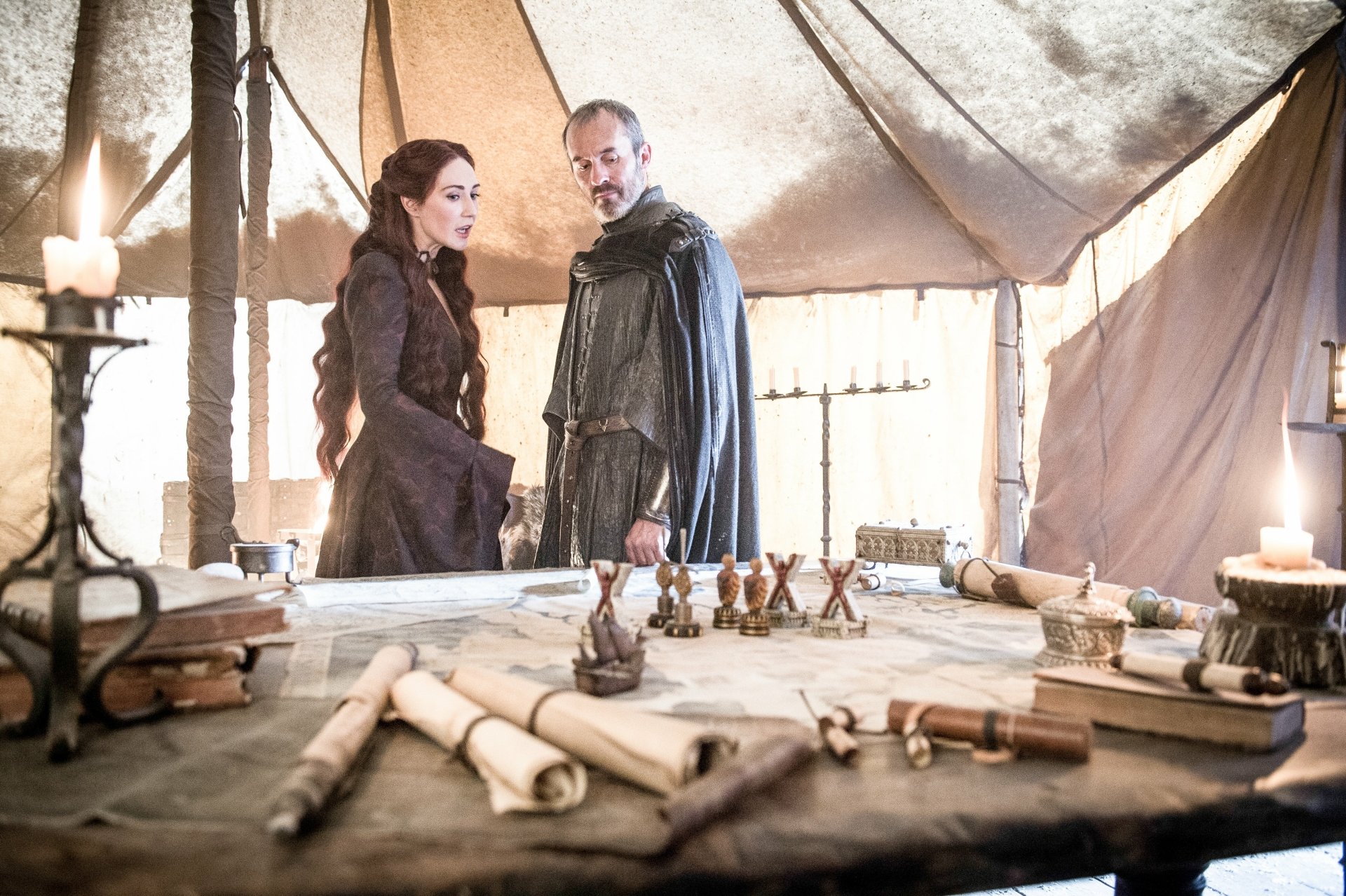 Stephen Dillane as Stannis Baratheon and Carice van Houten as Melisandre from Game of Thrones stand in a tent surrounded by maps and scrolls in this 4K Ultra HD wallpaper.