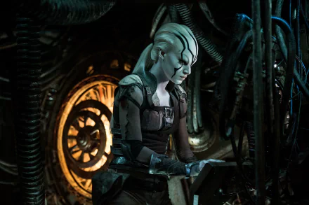 Sofia Boutella portrays Jaylah in this striking scene from *Star Trek Beyond*, showcasing her character in a futuristic setting amid intricate machinery.
