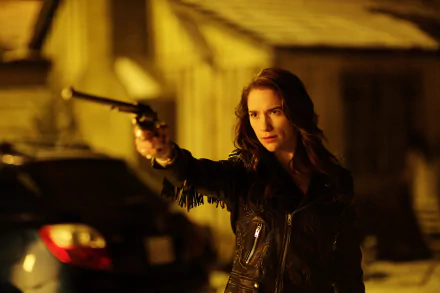 Wynonna Earp protagonist aims a revolver in a dim, gritty street scene — moody 2K Quad HD PC desktop wallpaper.