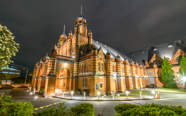 A stunning 4K Ultra HD image of a historic museum building in Australia, showcasing intricate architecture illuminated at night against a cloudy sky.