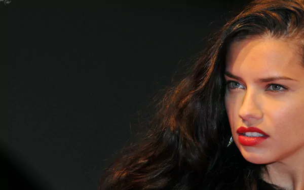 Close-up of Adriana Lima with flowing dark hair and striking red lipstick, presented as a 4K Ultra HD PC desktop wallpaper and background.